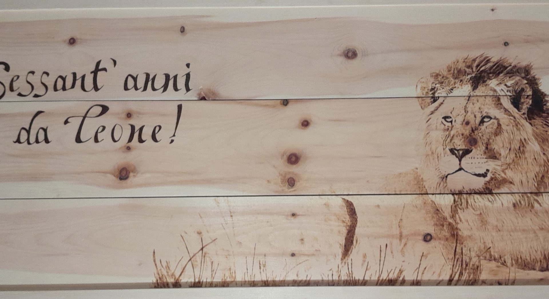 Sessant'anni da leone!. Pannello celebrativo in legno di cirmolo con cornice in abete. Pirografia, 2022.. Pirografia, 2022