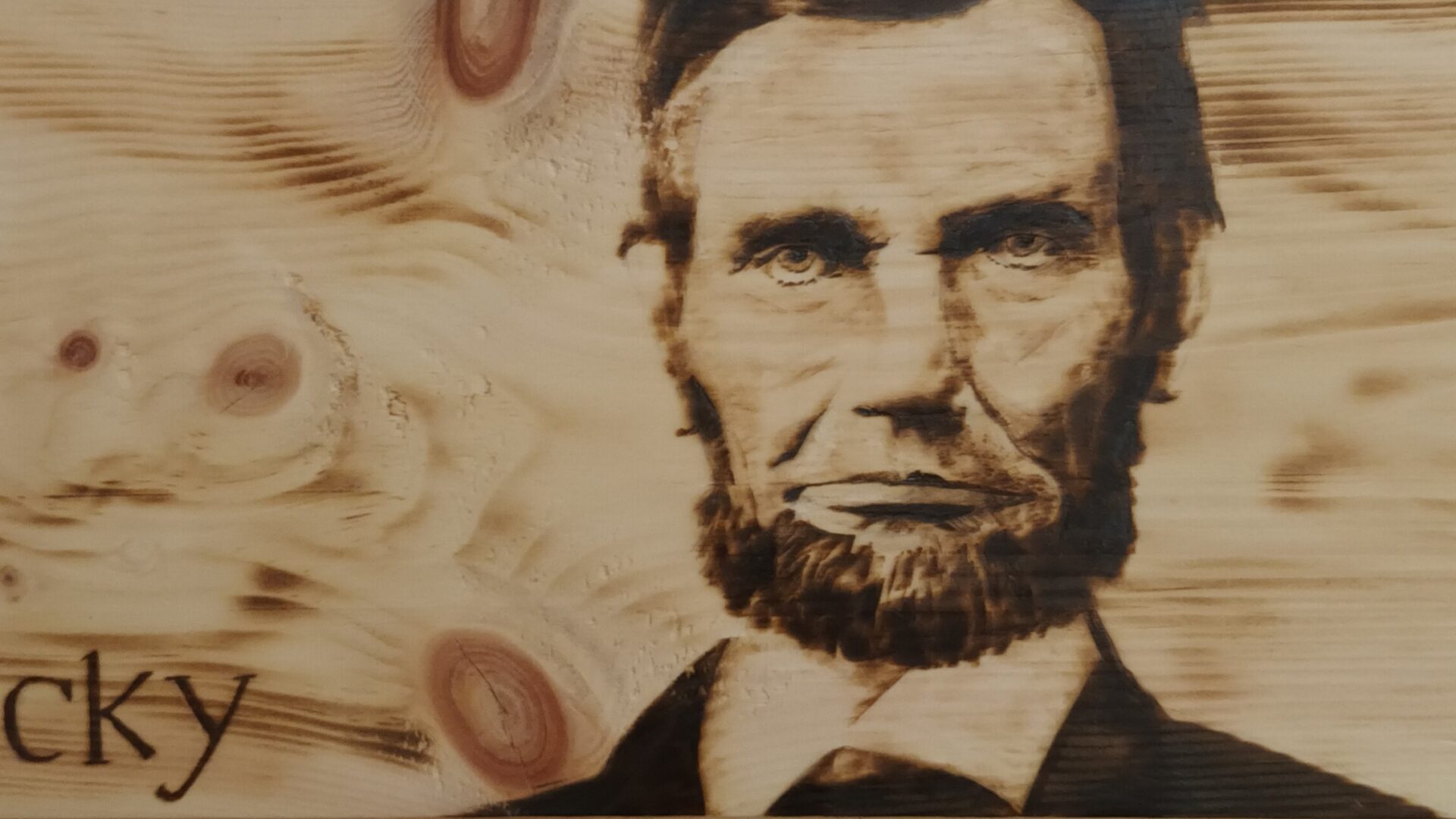Ritratto di Abraham Lincoln su legno di cirmolo. Pirografia, 2023.. Pirografia, 2023