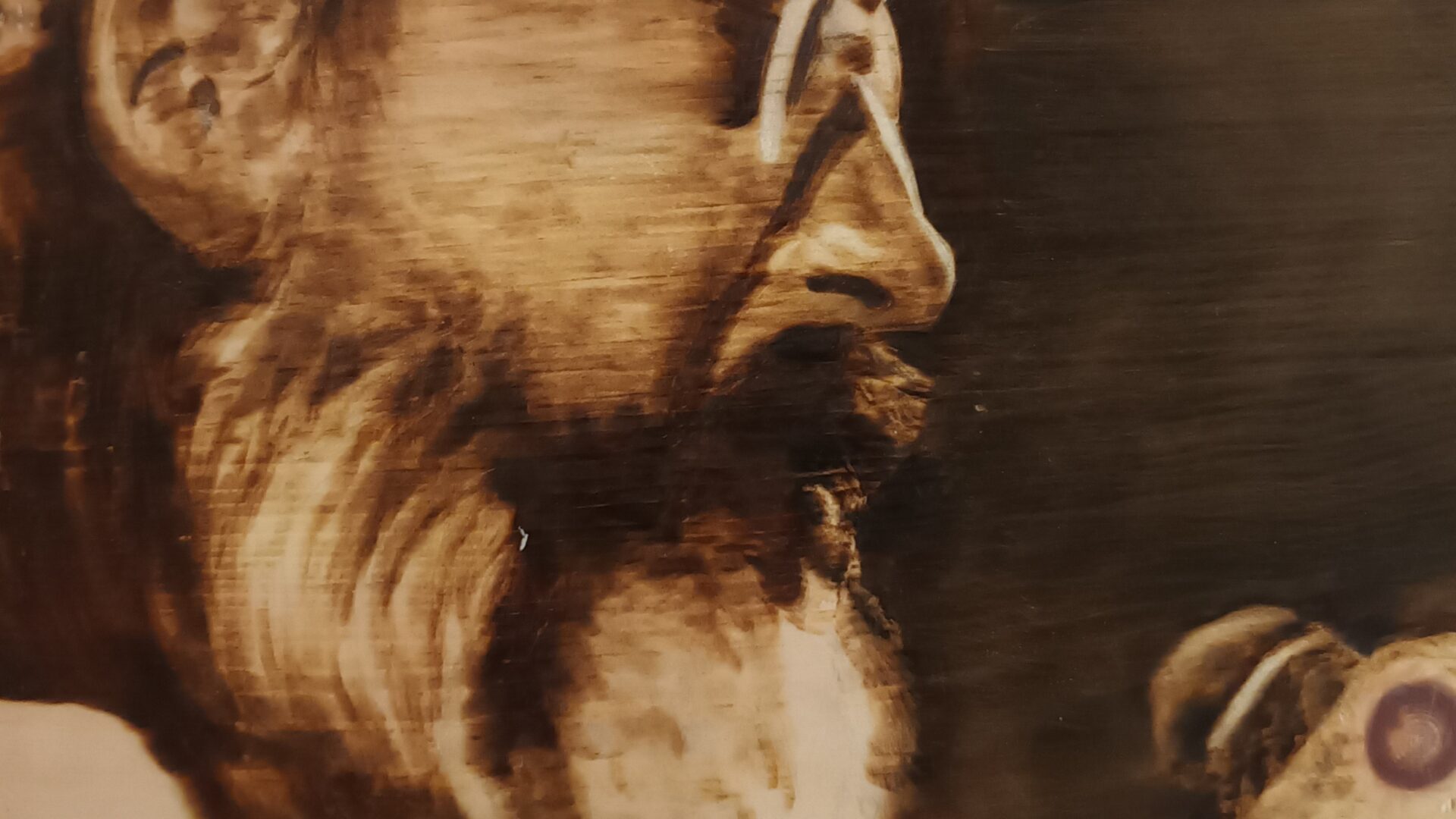 Ritratto di Augusto Daolio su legno di cirmolo. Pirografia, 2023.. Pirografia, 2023